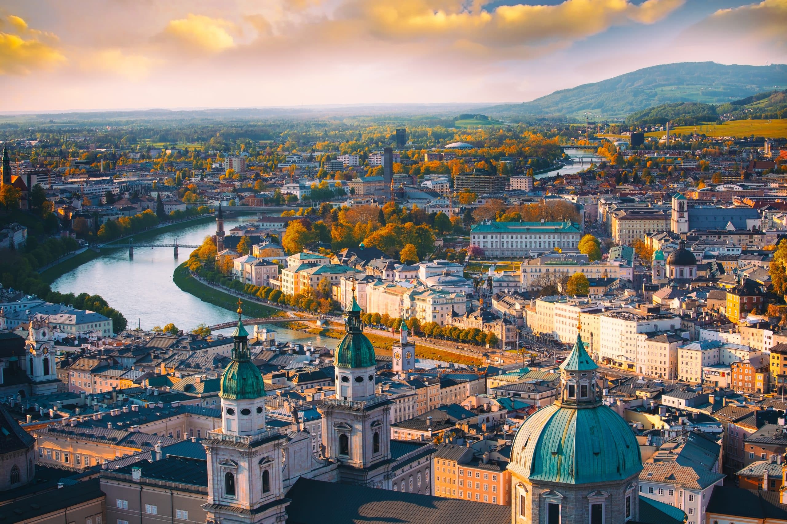 a historic city of Salzburg with Salzach river in beautiful golden evening light sky and colorful of autumn at sunset, Salzburger Land, Austria